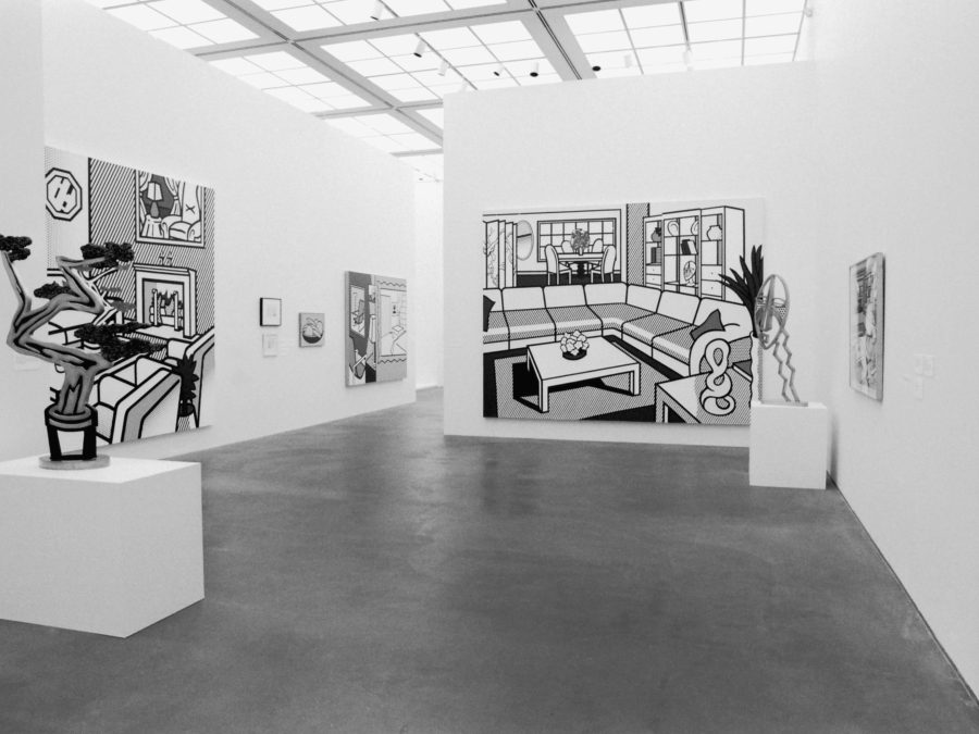 Black and white paintings and sculptures in a gallery space