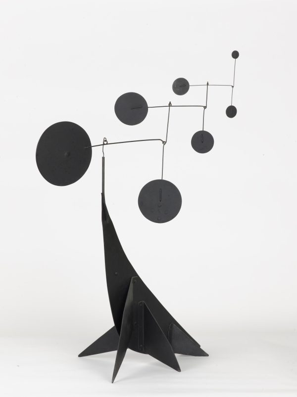 A black sculpture supports a mobile of circles decreasing in size