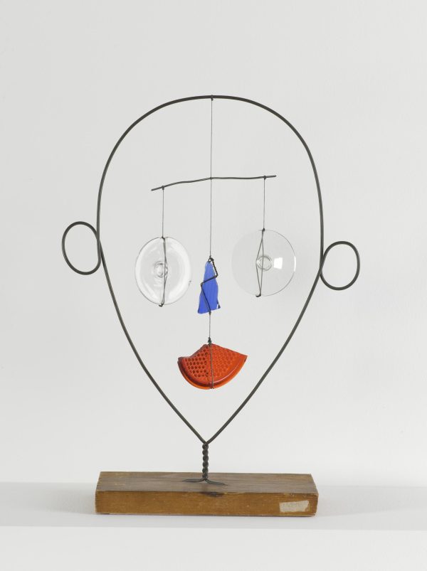 abstract sculpture of face with eyes, nose and mouth hanging as balanced mobile