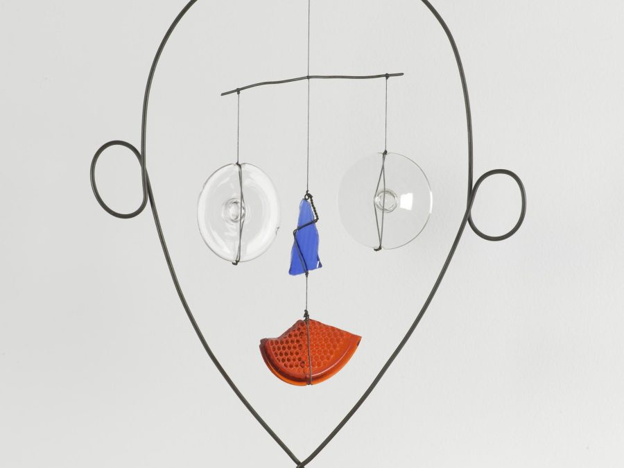 abstract sculpture of face with eyes, nose and mouth hanging as balanced mobile