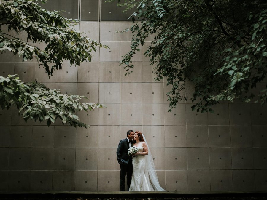 A couple poses for an intimate photo with the MCA facade serving as a backdrop for their luxury Chicago wedding