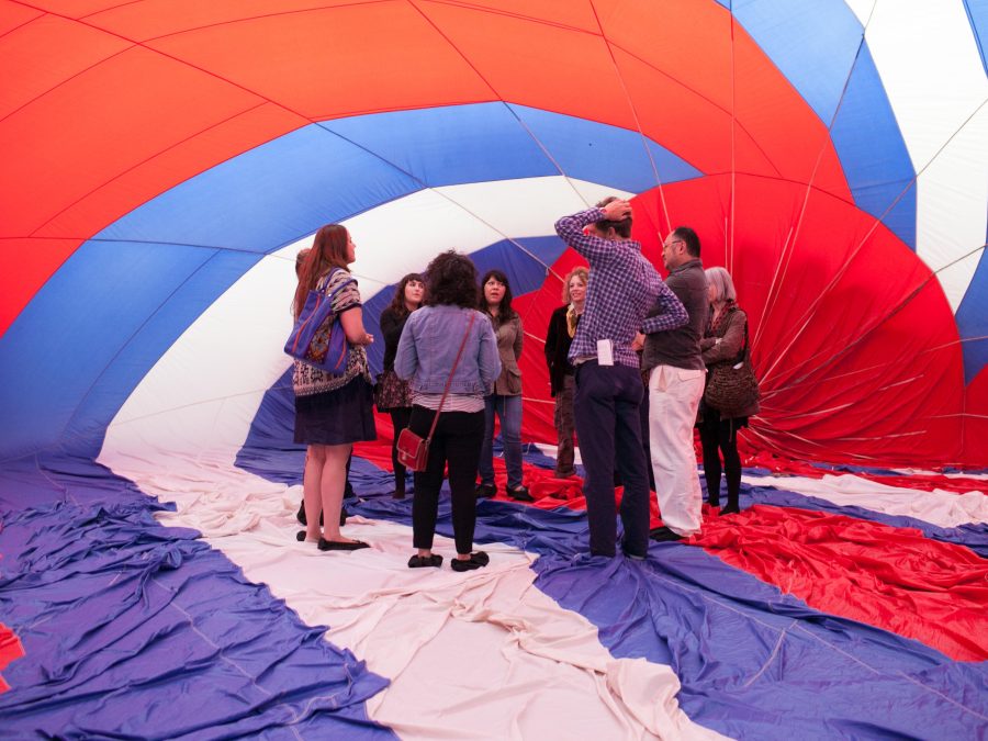 A group of people stands inside a large, fabric structure with red, white, and blue stripes.