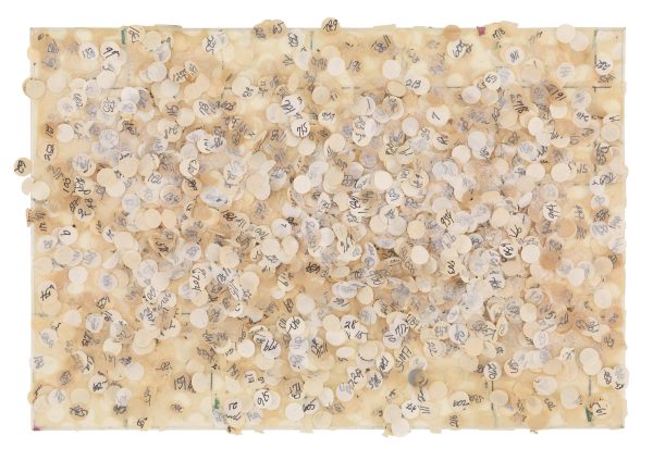 Multiple neutral-colored and numbered hole punches lie speckled across a rectangular surface.