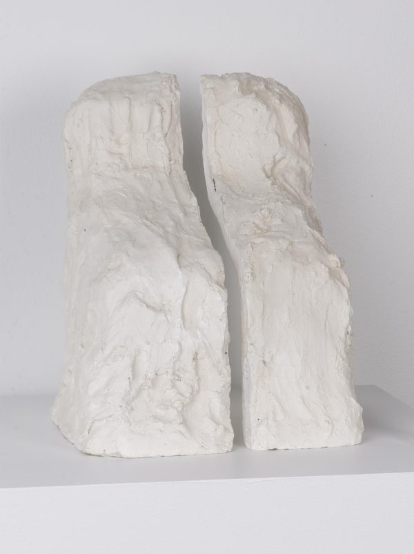A messy white plaster form has been cleaved into two halves, like bookends.