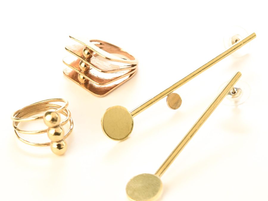 Two unique rings and a pair of earrings share a motif of gold circles and lines.