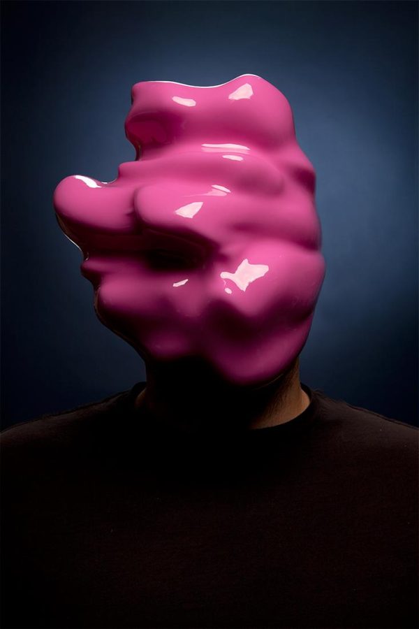 A portrait of a person reminiscent of a school portrait but the face is obscured by a shiny pink blob