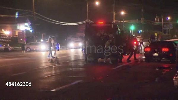 What appears to be a film still of a police or SWAT van on a street at night is watermarked with a Getty Images logo. People are walking on the street and emptying out the back of the van.