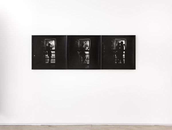 In a black-and-white triptych, the silhouette of a woman is visible holding a cigarette and looking out a doorway. In the second photo, a man appears at the door, and in the third, the silhouetted man and woman embrace.