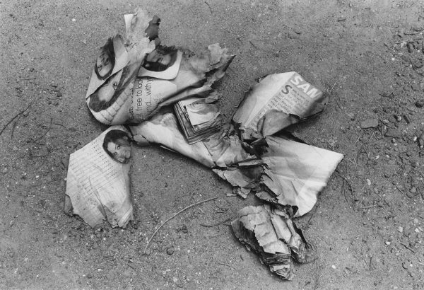 A small pile of burned images. Just visible are four people's heads on some of the remaining scraps.