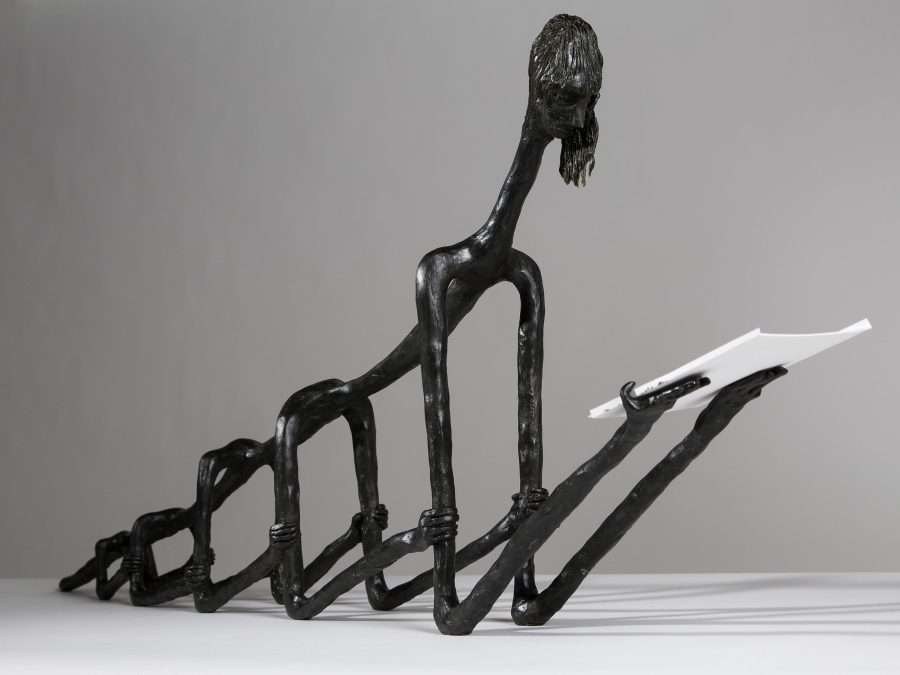 A black, bearded figure's body is composed of five pairs of spindly arms, each grabbing the pair in front them.