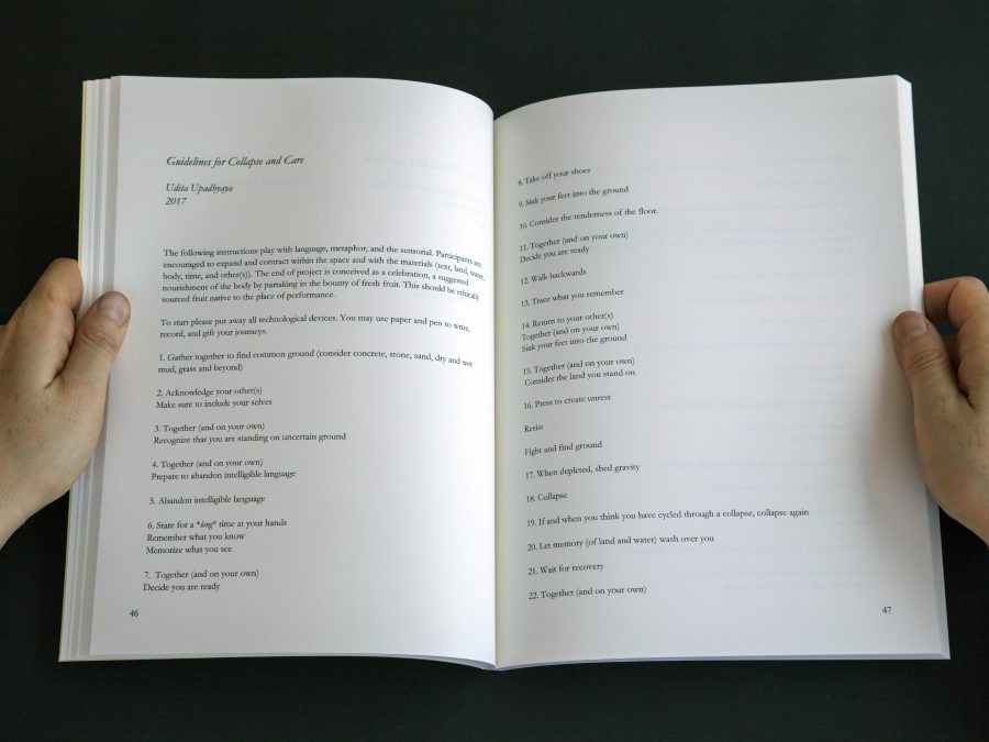 Two hands hold a book open against a dark background.