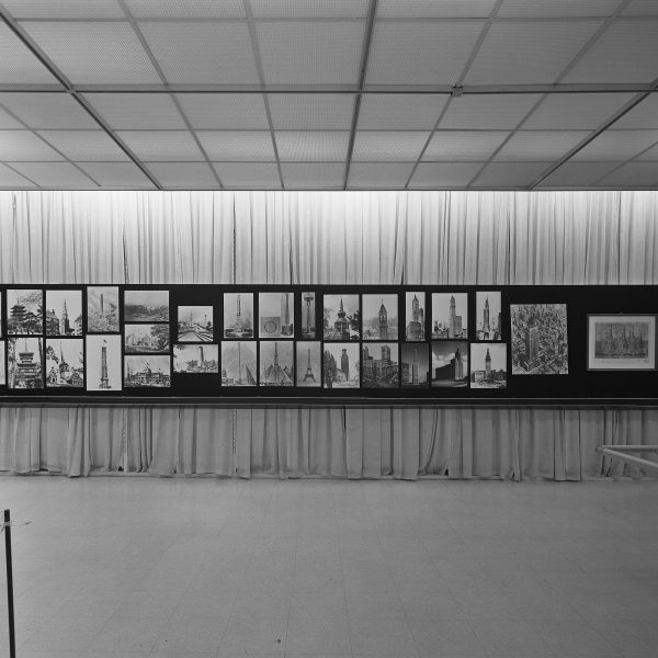 A long horizontal posterboard displaying more than 20 images of towers