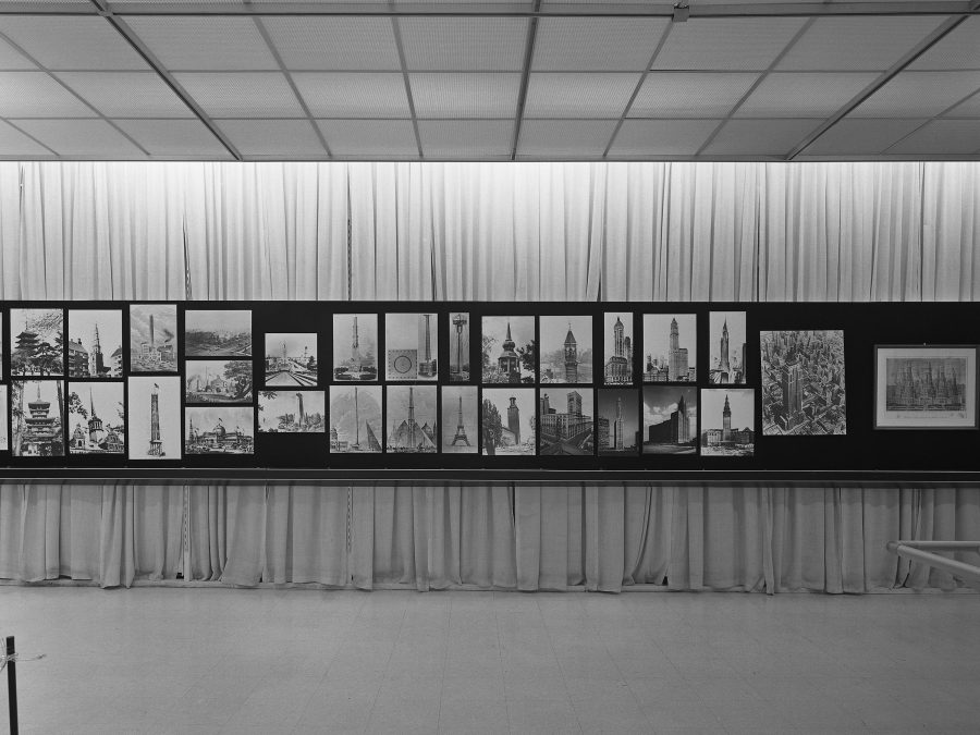 A long horizontal posterboard displaying more than 20 images of towers