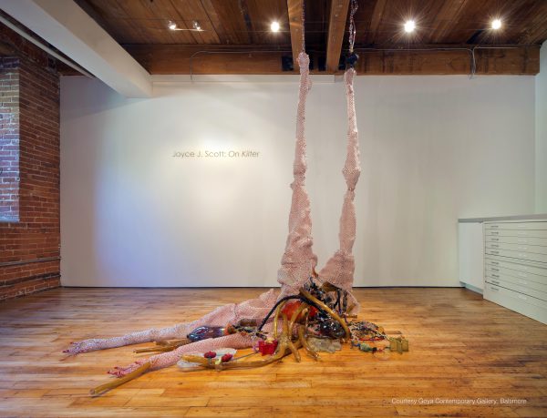 Sculpture hanging from the ceiling and spilling on to the floor of a gallery space.