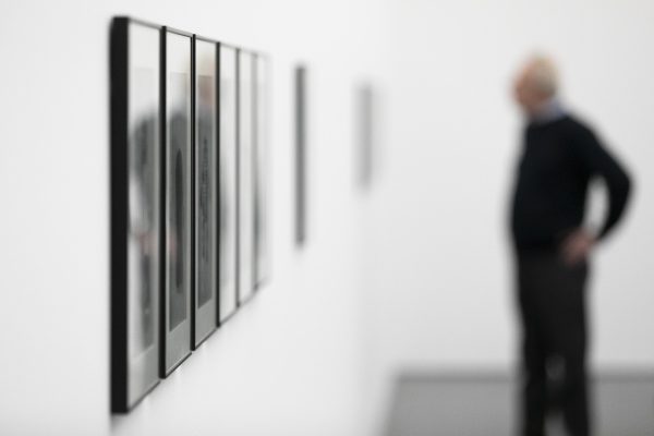 A blurred photo of a man looking at a gallery