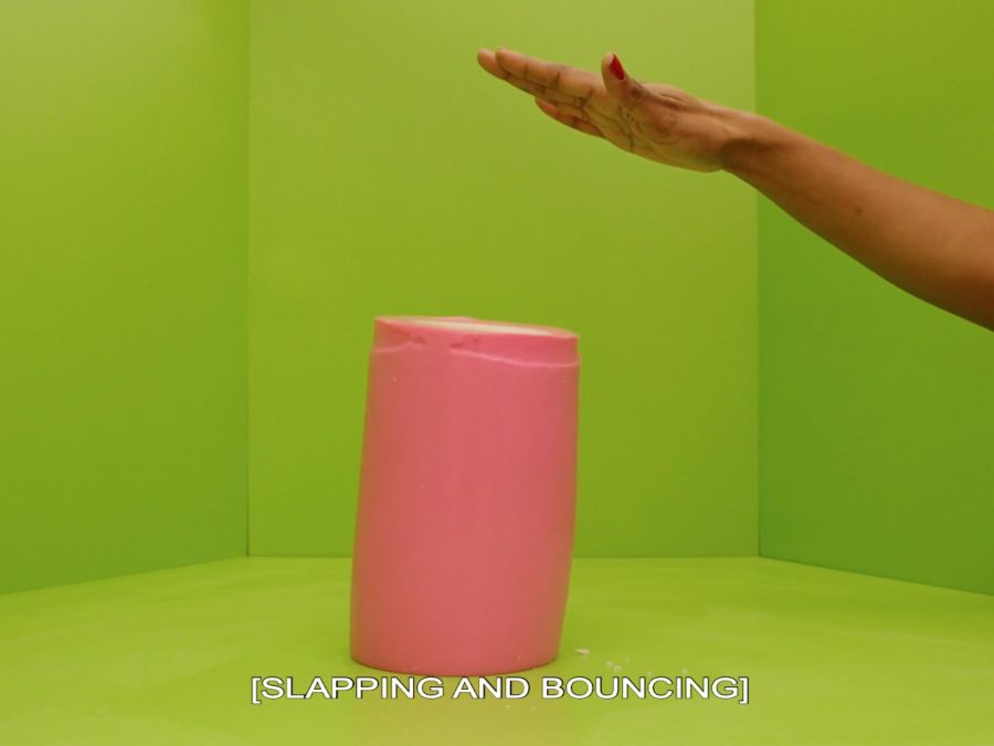 An arm extends into a lime-green room. A pink, gelatinous cylinder appears to have been slapped by the hand. Text on the image says [SLAPPING AND BOUNCING].