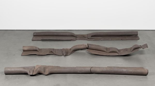 Three bent, crushed, or twisted brown objects resembling pipes