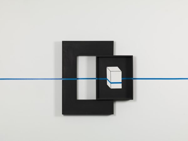 A black box containing an image of white box is mounted on the side of a thick black frame. The entire piece is intersected by a horizontal blue line, which appears to be painter's tape.