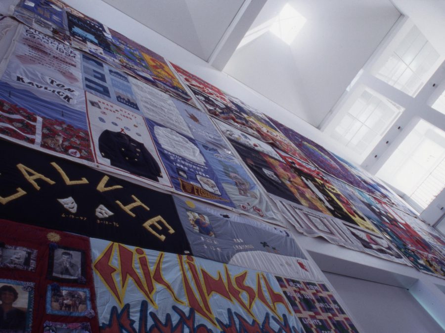 Large fabric panels with text and images cover a wall in a two-story room
