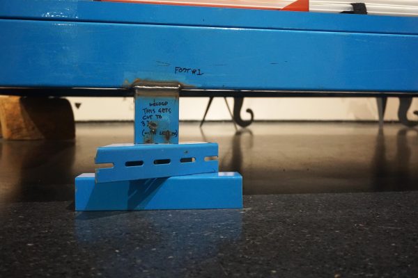 Close up of the bottom of a blue shelving unit.