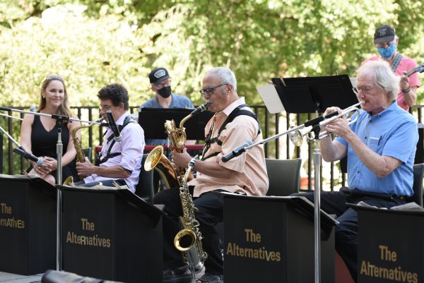 A seven members of a band playing music outside