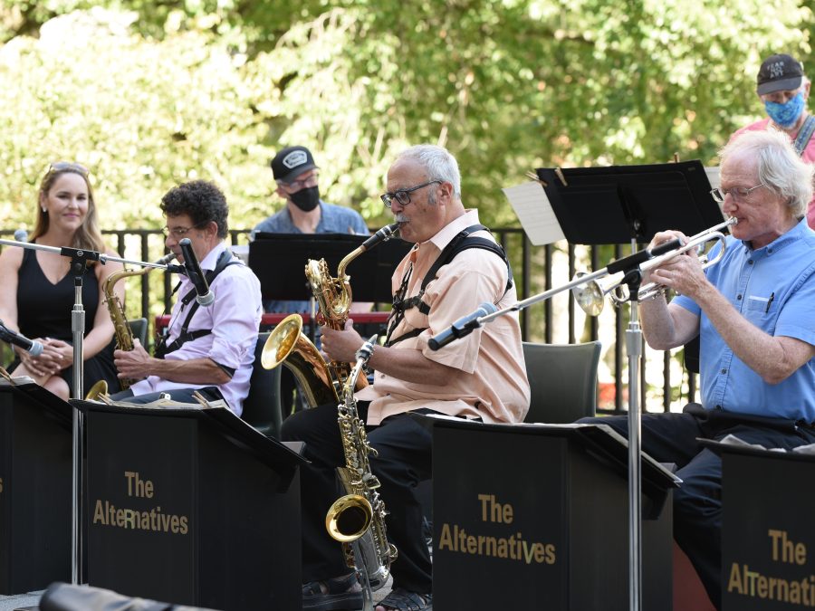 A seven members of a band playing music outside