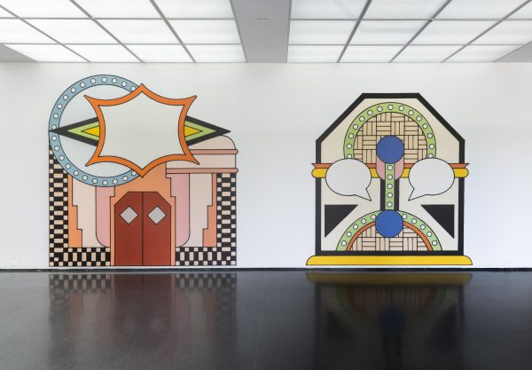 Exhibition interior with large, comic-style artwork on the walls