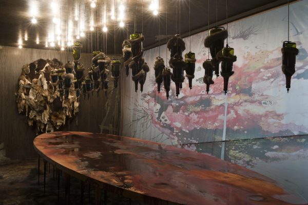 sculpture of figures hanging from gallery ceiling