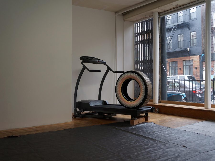 in an empty room a large tire is placed on a treadmill